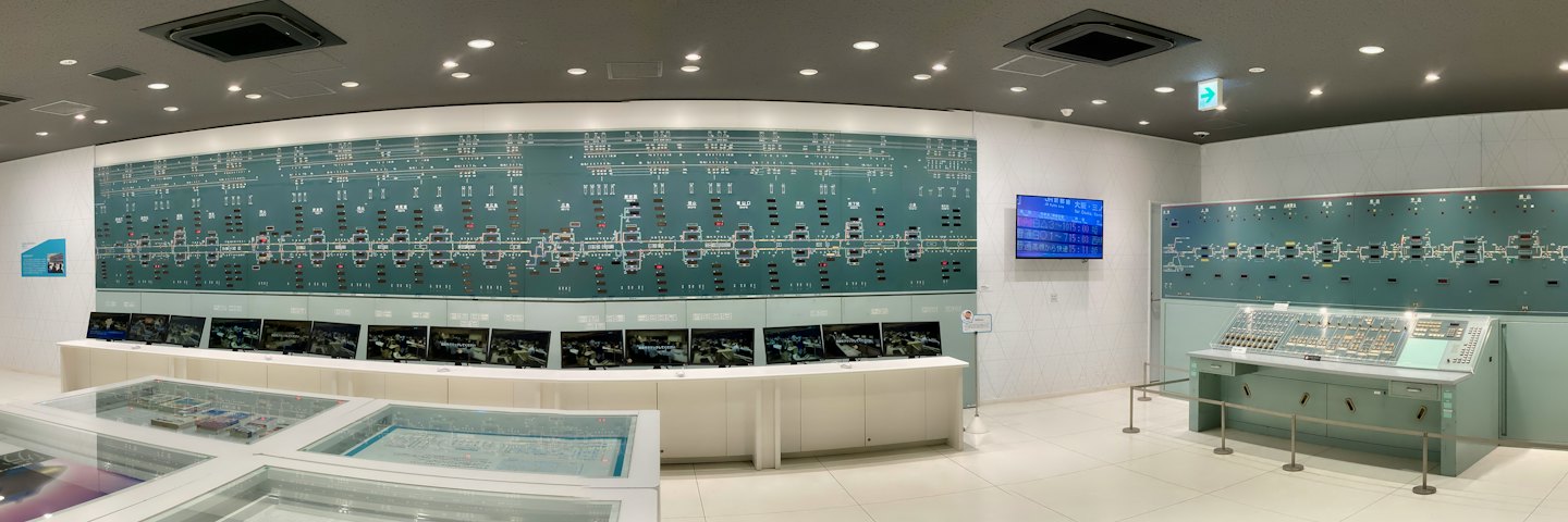 Modern train control room featuring monitors and a large track diagram.